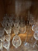 Cabinet shelf with assorted crystal and glass stemware in various sizes and patterns
