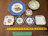 All seven dishes laid out with measuring tape showing size range