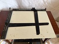 Top view of Pixur steel board showing white surface, black rails, measurement scales