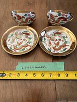 Complete set: two teacups and two saucers with measuring tape for scale