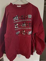 Full view of red crewneck sweatshirt on hanger