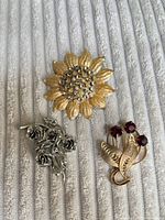 Overview of three brooches on fabric background