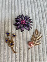 Front view of all three brooches showing designs and colors