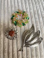 All three brooches grouped on fabric background