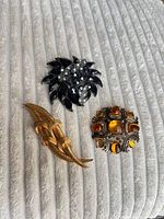 All three brooches displayed together