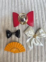 Front view of all five brooches showing colors and designs