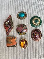 Front view showing all seven brooches and design details