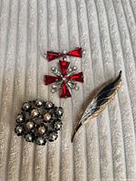 Overview of three brooches on fabric background