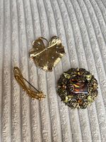 All three brooches laid out on fabric surface