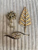 front view of all three brooches displaying designs and stones