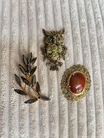 Front view of all three brooches on fabric