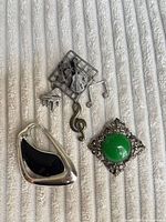 Front view of three brooches on fabric