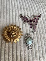 Front view of all three brooches showing designs and colours