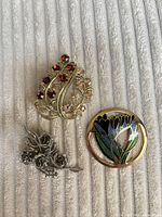Front view of all three brooches showing designs and colors