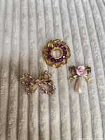 All three brooches laid out together showing overall design and colour