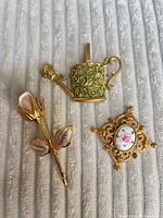 Front view of all three brooches on fabric backdrop