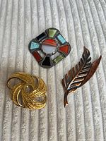 All three brooches displayed on fabric