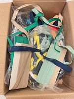 Box with folded beige, navy, teal and multicolour elastic straps