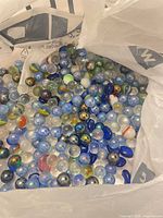 Full view of plastic bag filled with mixed glass marbles