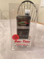 Front view of sealed Pro-Tech H-1000 breathalyzer showing LED meter, controls, red burst label