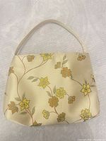 Front view of floral handbag showing fabric, print and handle