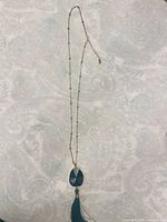 Full view of necklace showing chain, pendant and tassel