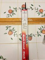 Box containing Titan black music stand