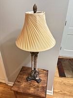 Full view of table lamp showing base, column, shade, and finial