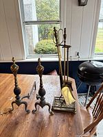 Full view of stand with tools and pair of andirons on table