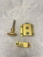 Latch components laid out: spindle with knob, lock body, strike plate