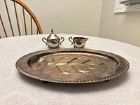 Tray, creamer and lidded sugar bowl showing size, design and tarnish