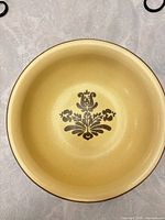 top view of yellow/cream stoneware bowl showing floral motif and rim detail