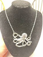 Front view of octopus pendant on display bust