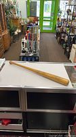Full view of Louisville Slugger K55 baseball bat on counter
