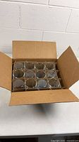 Open box showing 12 partitioned beakers