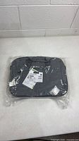 Front view of sealed grey Lenovo laptop bag with tag