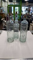 Front view of all three clear decorative bottles with corks