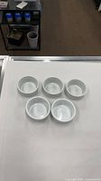 Five white ramekins arranged on table