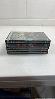 Stack of five DVD cases edge view showing titles