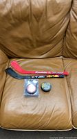 Overall view of Franklin mini stick and two pucks on couch