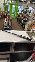 Full view of black Louisville Slugger bat on counter