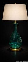 Full view of emerald glass table lamp with shade