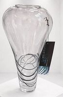 Full view of clear glass vase showing internal black swirl and hang tag