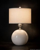 front view of white ceramic globe lamp base with shade shown for scale