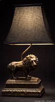 Lion sculptural table lamp front view showing lion figure, stepped base and shade