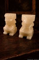 Front view of both stone guardian figures showing overall form and material