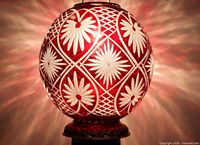 Lamp shade lit, showing full spherical form and cut floral/lattice design