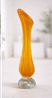 Front angled view of amber glass vase showing asymmetrical mouth and base