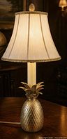 full view of brass pineapple lamp base with finial and attached power cord