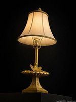 Full view of gilt bird motif lamp with shade for scale